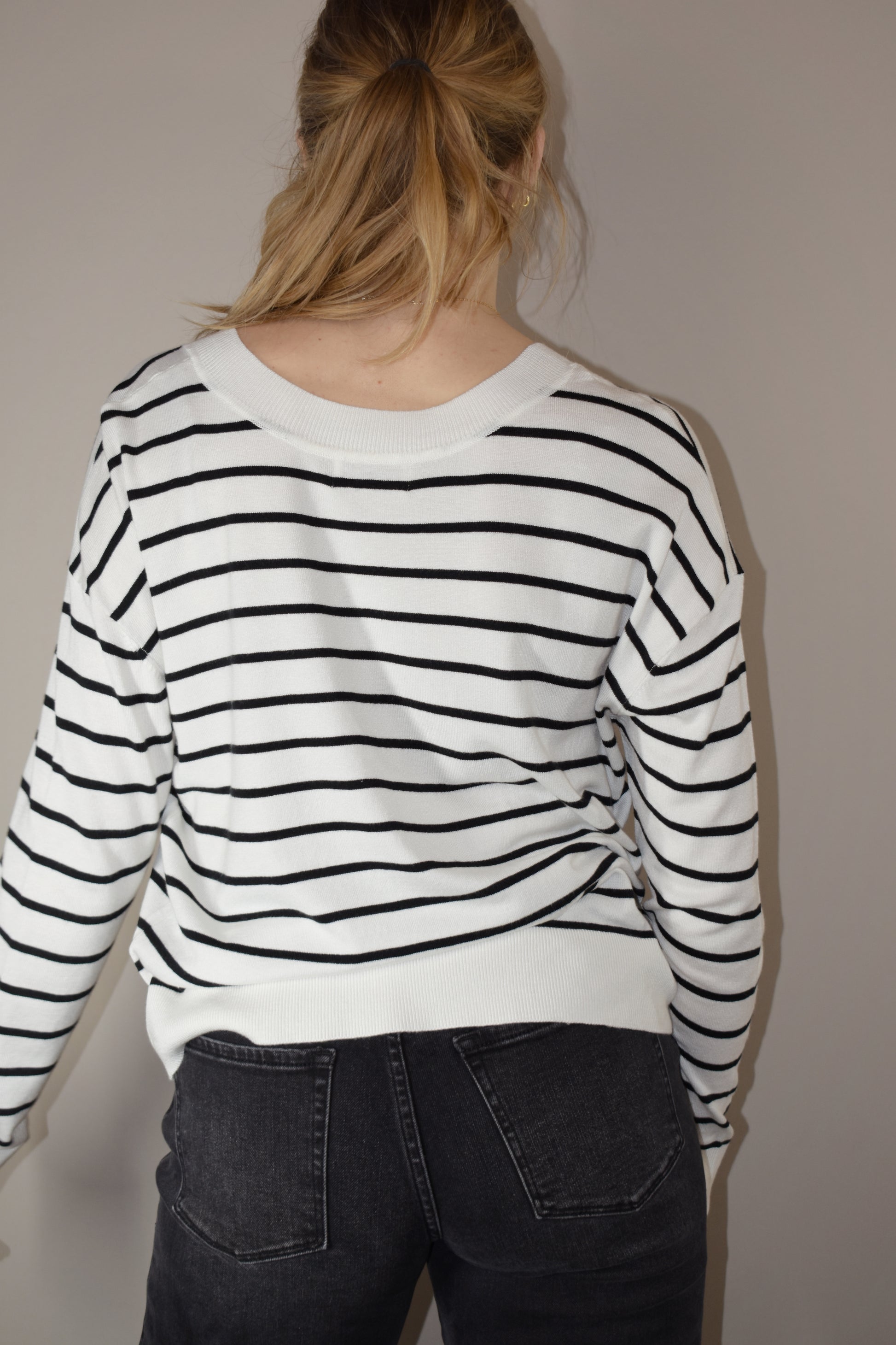 long sleeve full length v neck light weight sweater with horizontal black stripes, solid white hem, loose fit, drop shoulders, super soft.