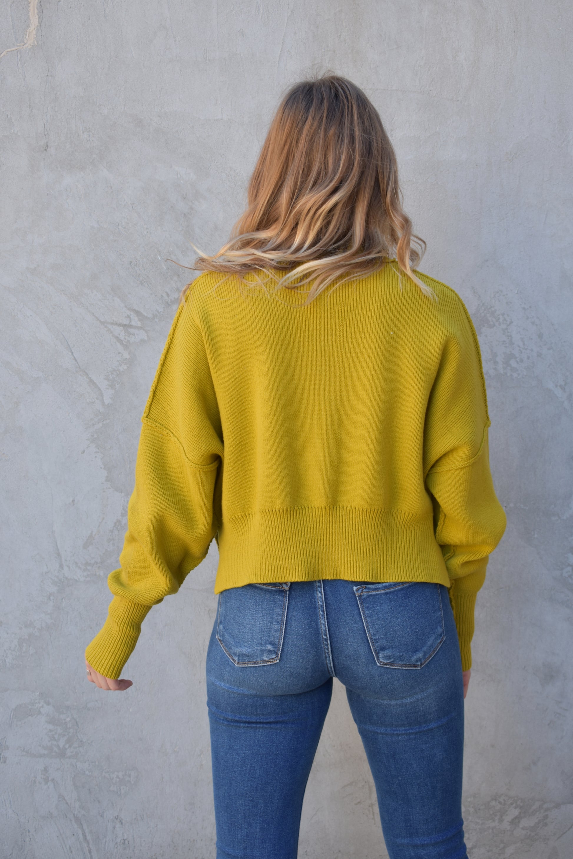 slouchy mock neck sweater with exposed seams, drop shoulders, slightly oversized and slightly cropped, wide ribbed cuffs and hem, split on side of hem