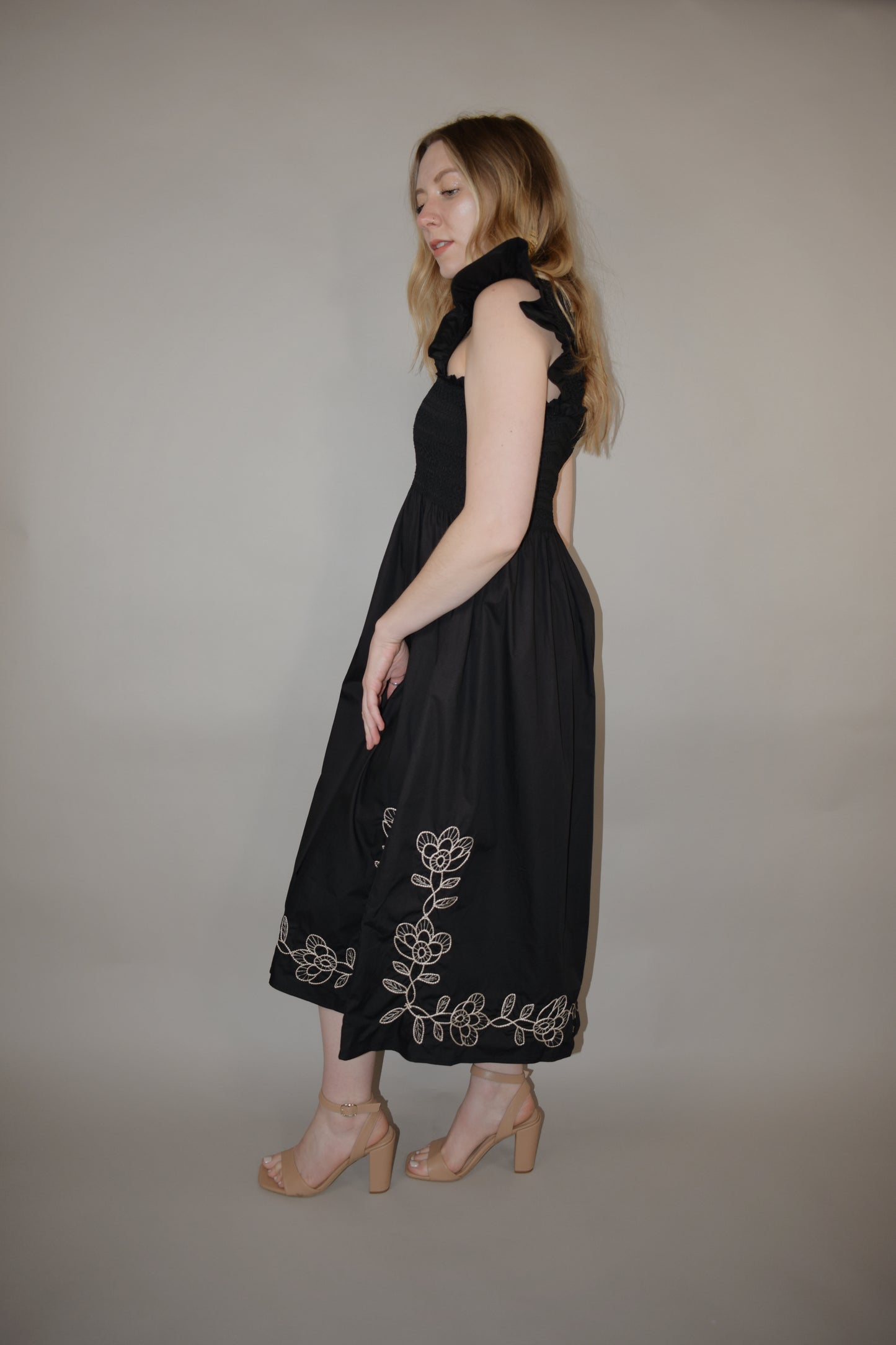 black midi dress with cream embroidered flower vine along hem, smocked bodice, square neckline, flutter shoulder detail, flowy yet tailored feel