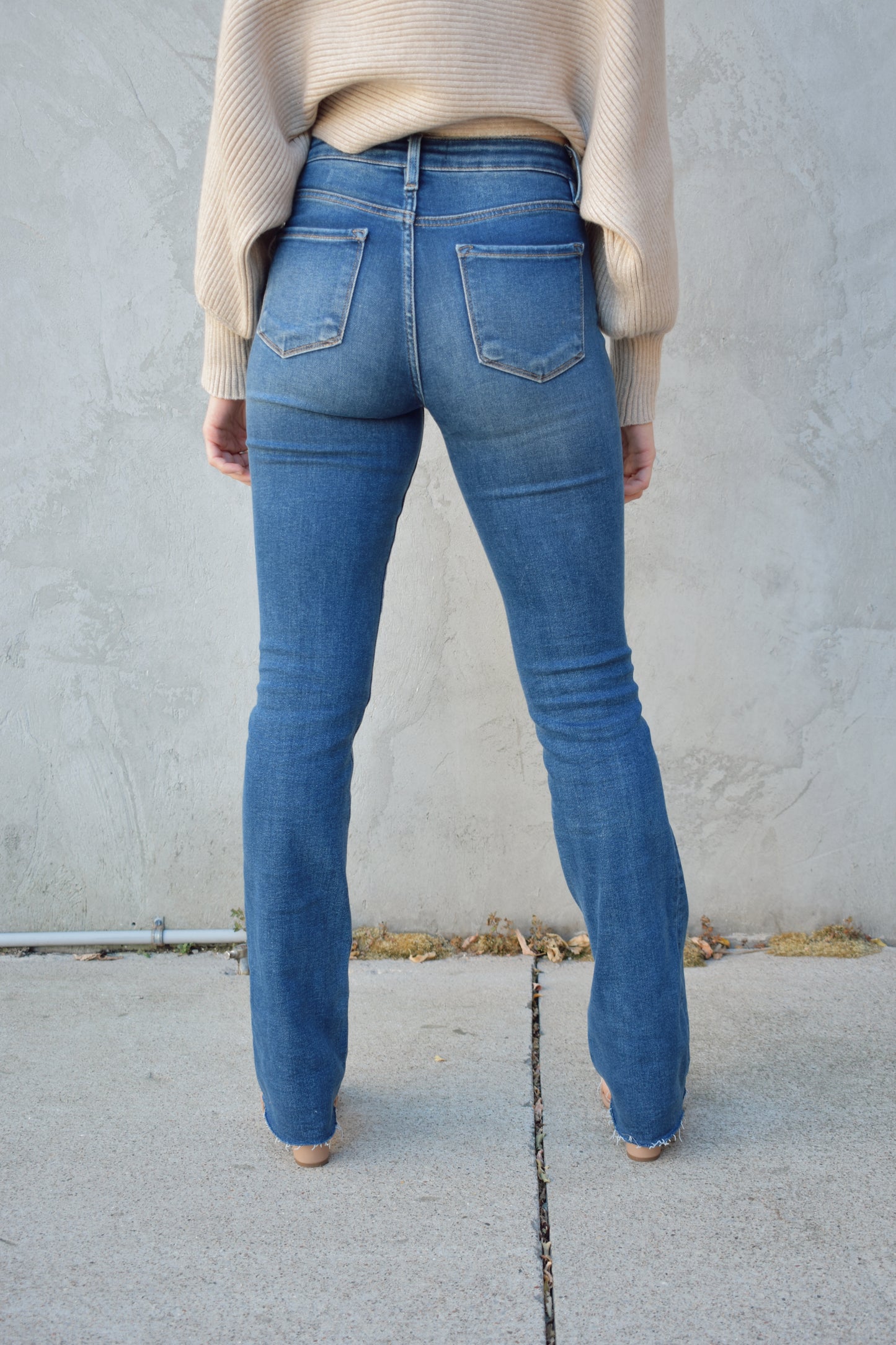 medium wash stretch denim bootcut jeans with zip and button enclosure. no distressing.