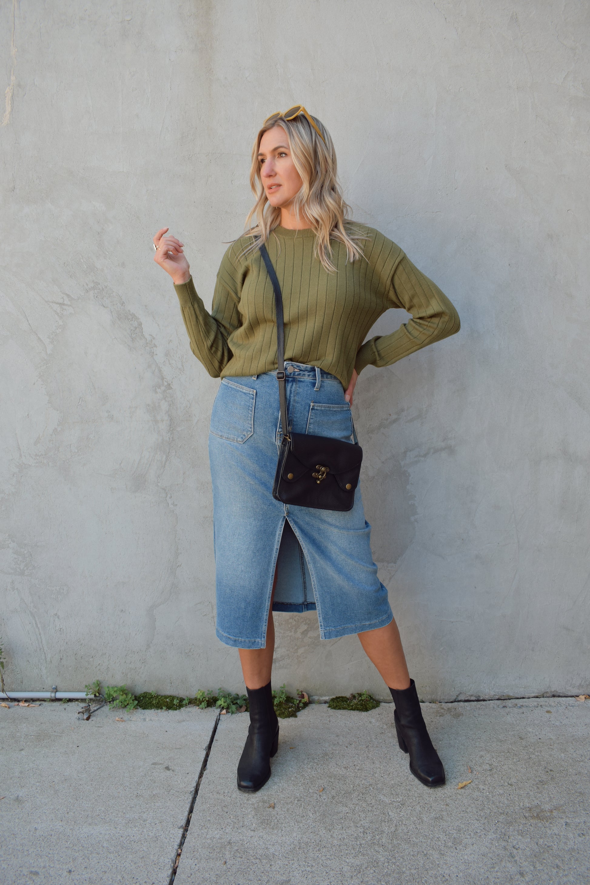 medium to light wash denim midi skirt with front slit, front patch pockets, zip and button enclosure, beltloops, back pockets, no distressing.