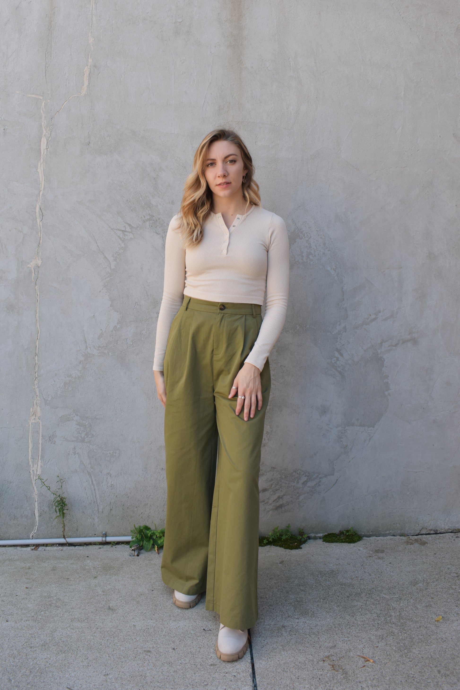 Super wide leg olive green twill trousers with pleats at the top. high waisted with zip and button enclosure. has beltloops and pockets. full length. good for tall ladies.