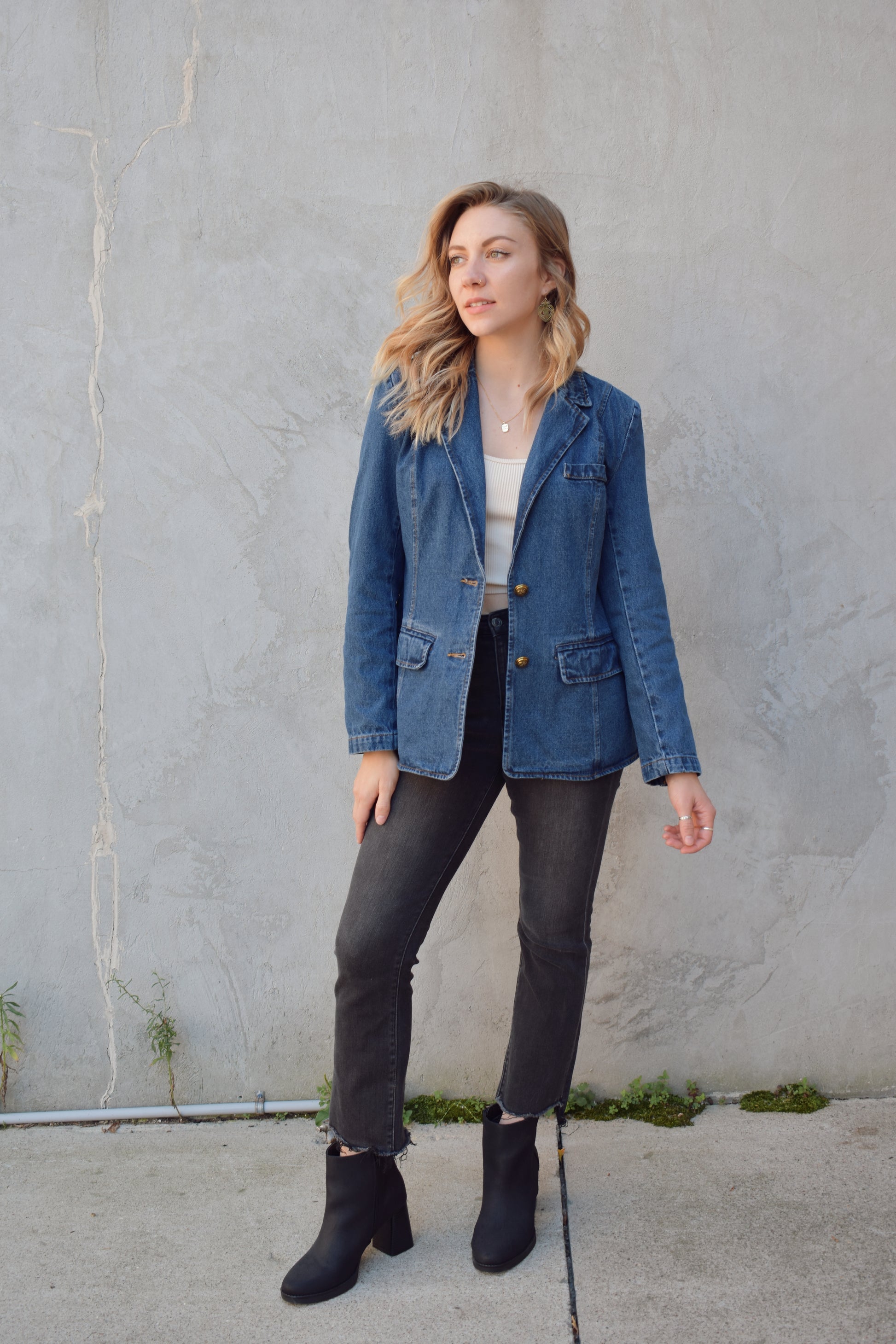 dark wash denim blazer with two gold buttons with an anchor design on them.  pockets with flaps on top, one breast pocket, fitted. full length. slit on back middle hem