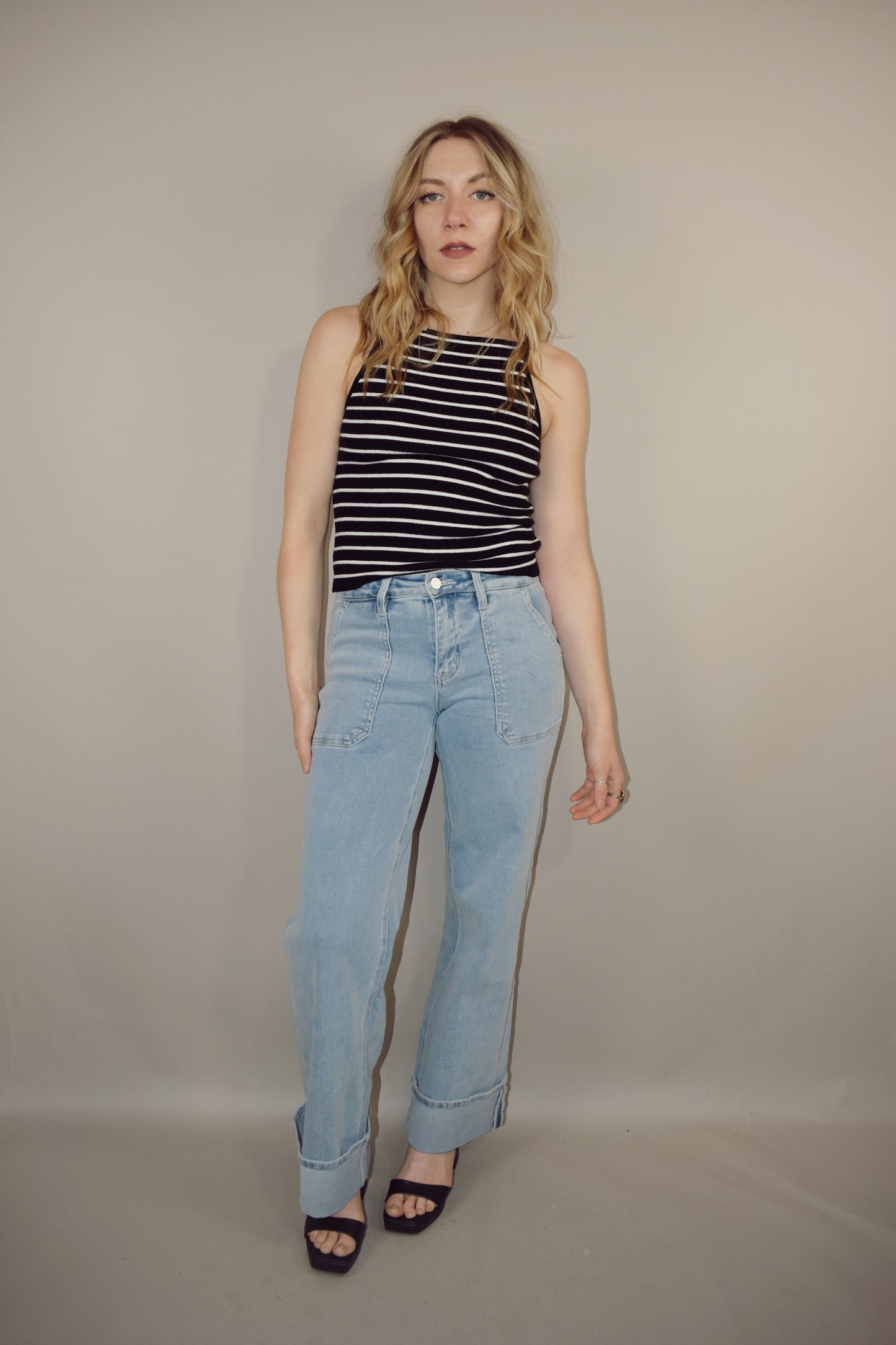 wide leg cuffed light wash stretch denim jeans with deep front patch style pockets and has a side carpenter pocket, no holes, zip and button enclosure, high rise.