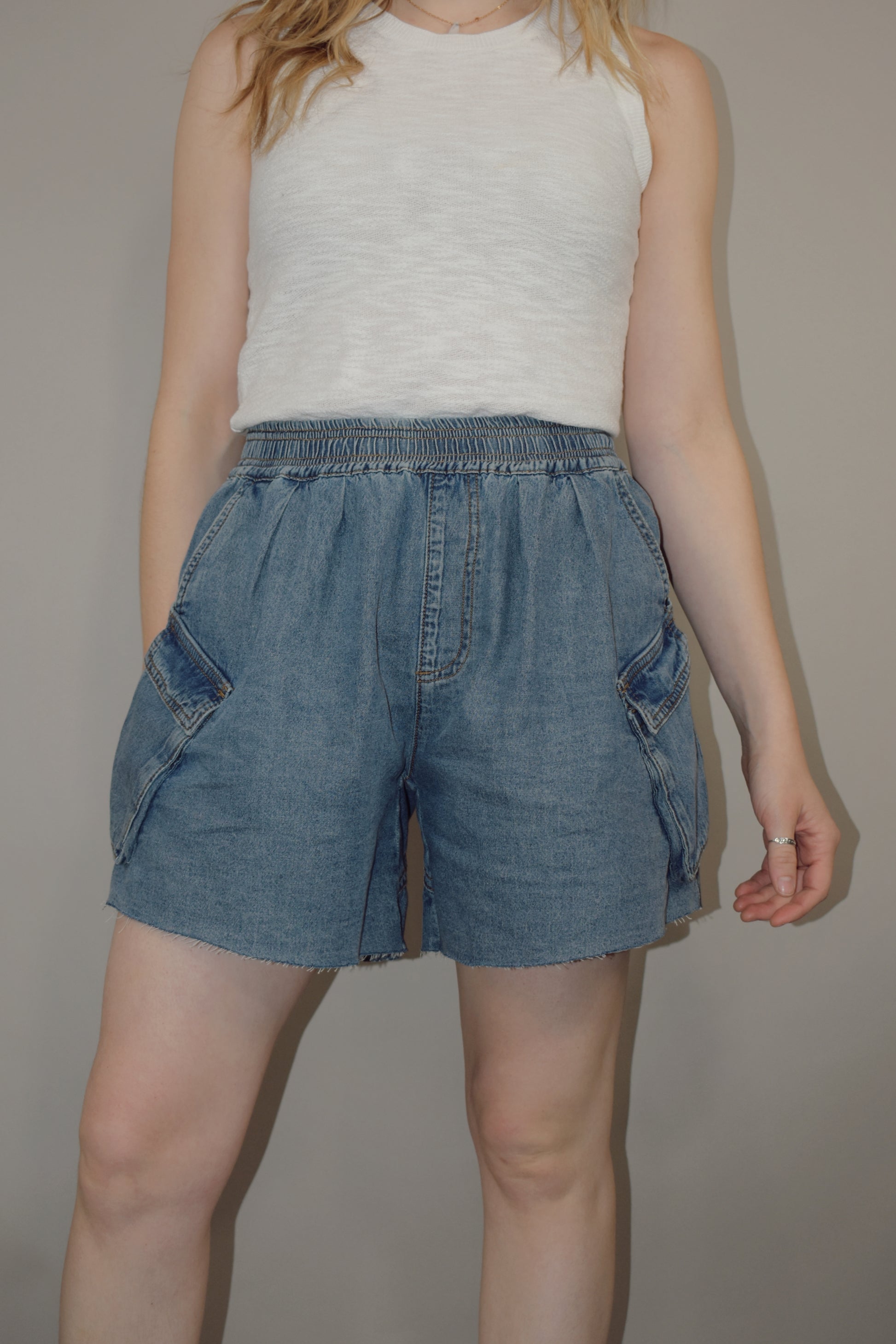 tencel denim effect baggy shorts with raw hem, elastic waistband, cargo pockets along with multiple side pockets, seam detailing, medium wash