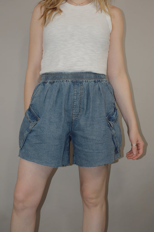 tencel denim effect baggy shorts with raw hem, elastic waistband, cargo pockets along with multiple side pockets, seam detailing, medium wash