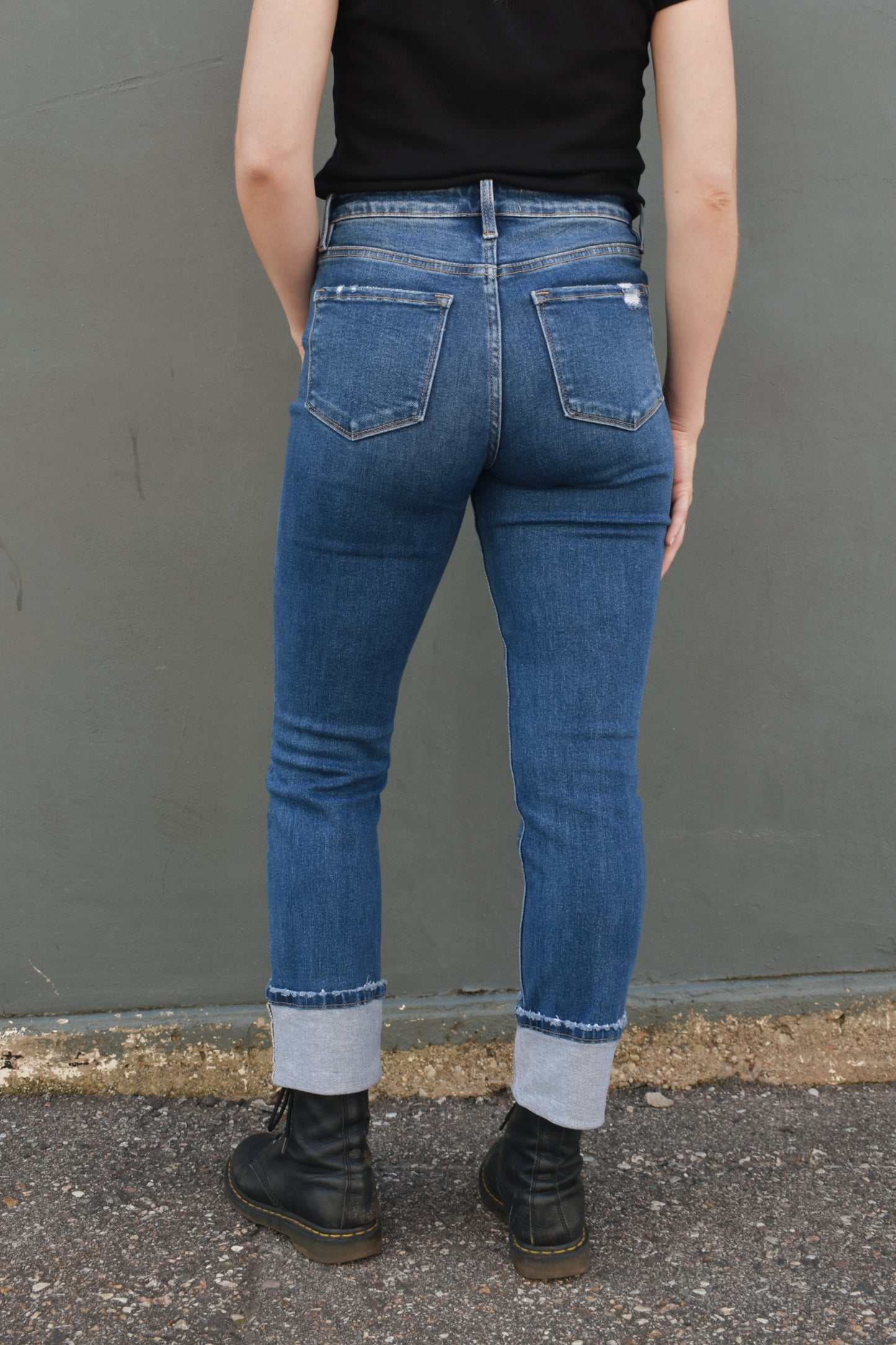 medium wash straight jeans with thick cuff, no holes, light distressing around pockets and at hem, stretch denim