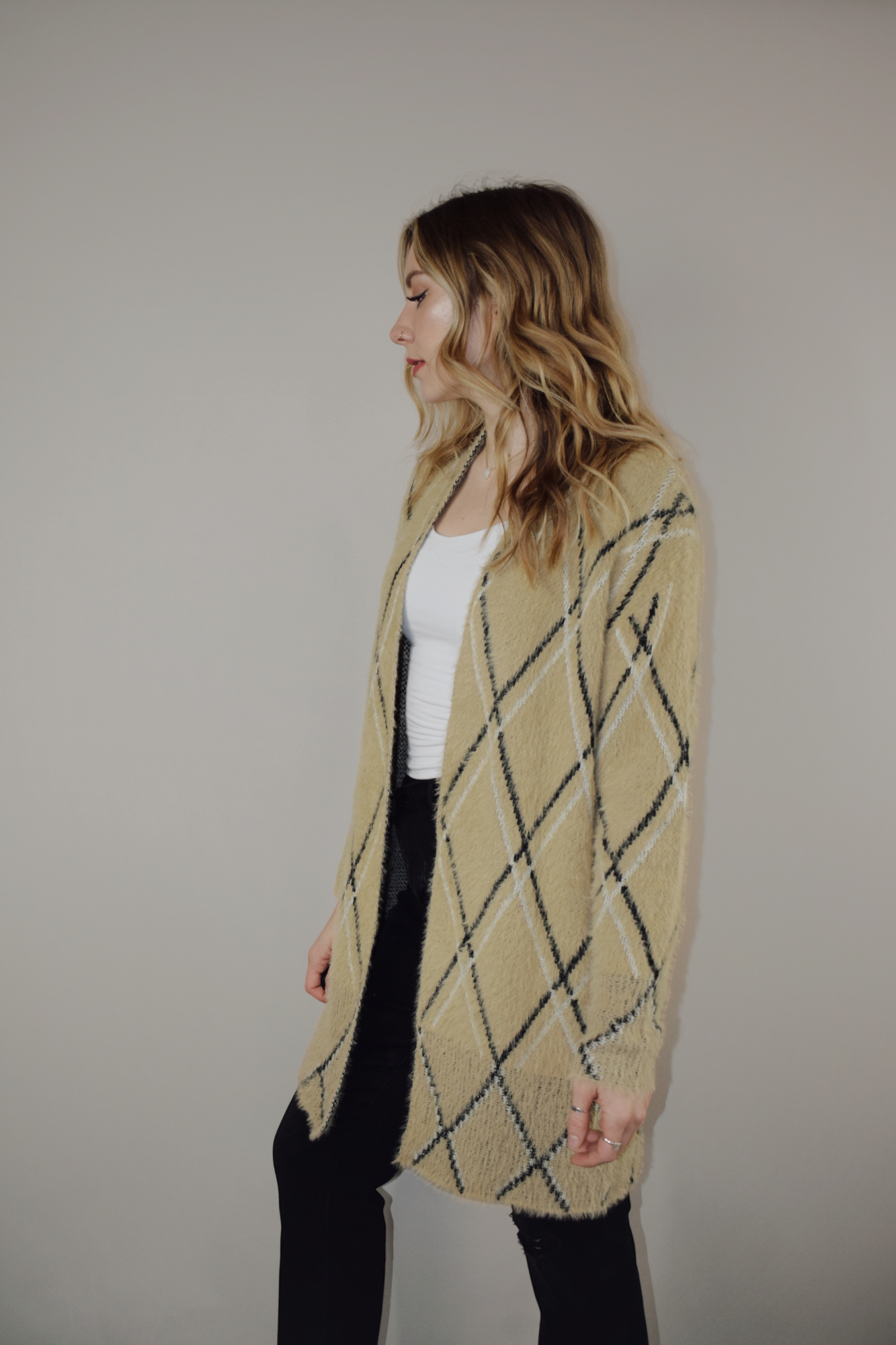 super plush open cardigan with tan background and black and white lined diamond design. hits at mid thigh.