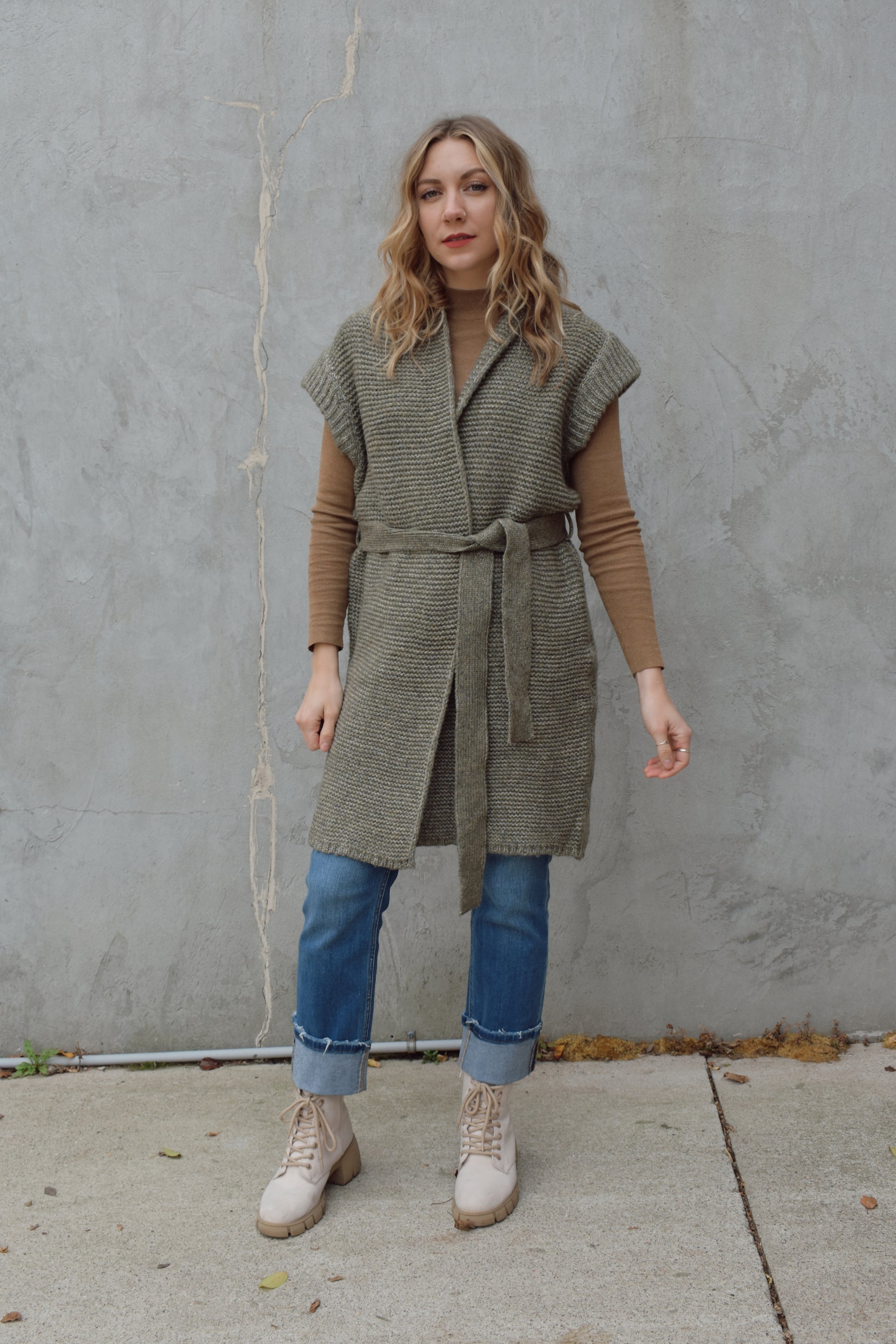 belted sleeveless cardigan vest with thick cap sleeve detail. woven olive green material. hits above the knee.