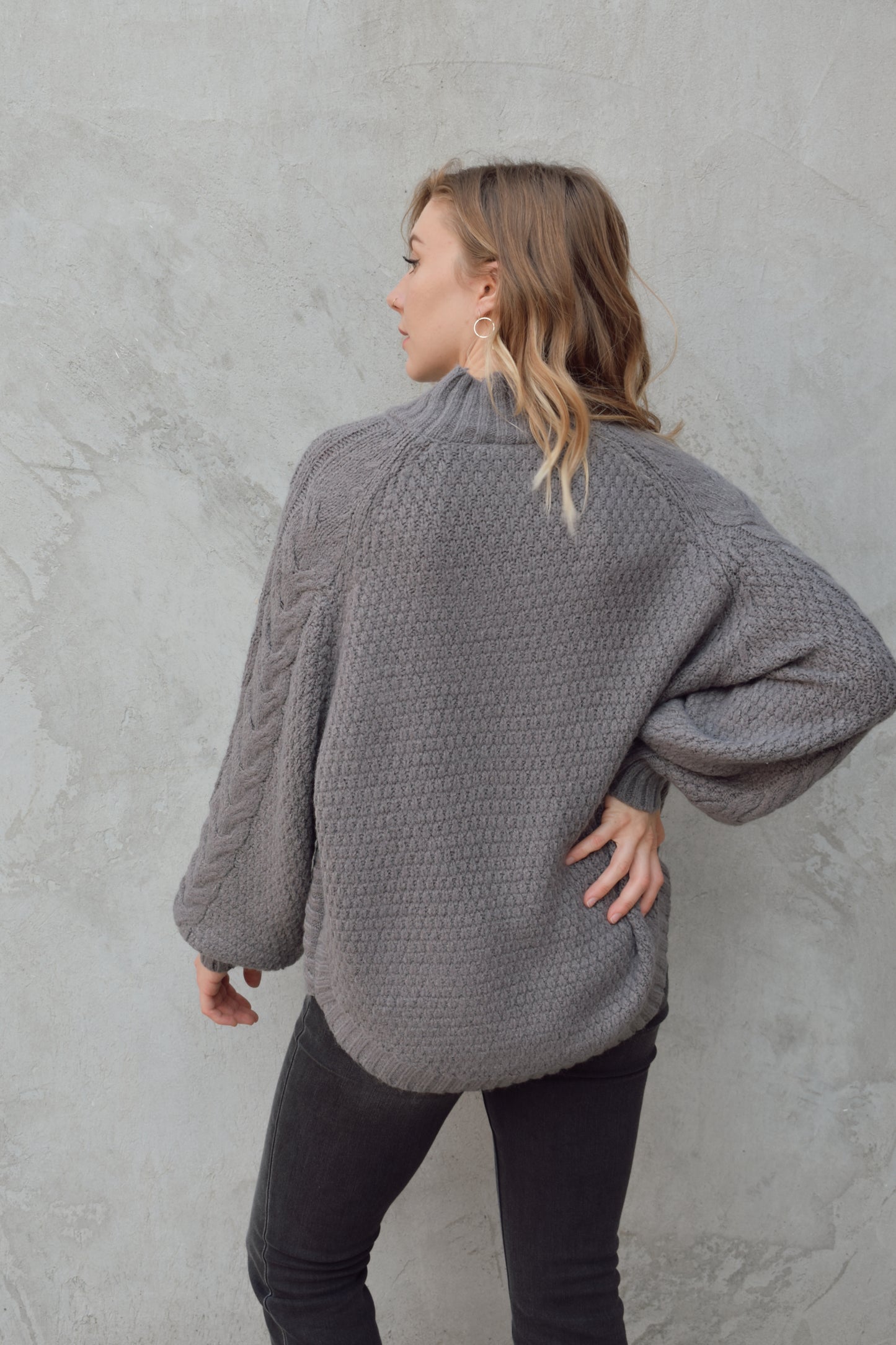 mock neck full length sweater with ribbed detailing around trim and chunky cable knit down the front and down the sleeves. rounded hem, slouchy sleeves.