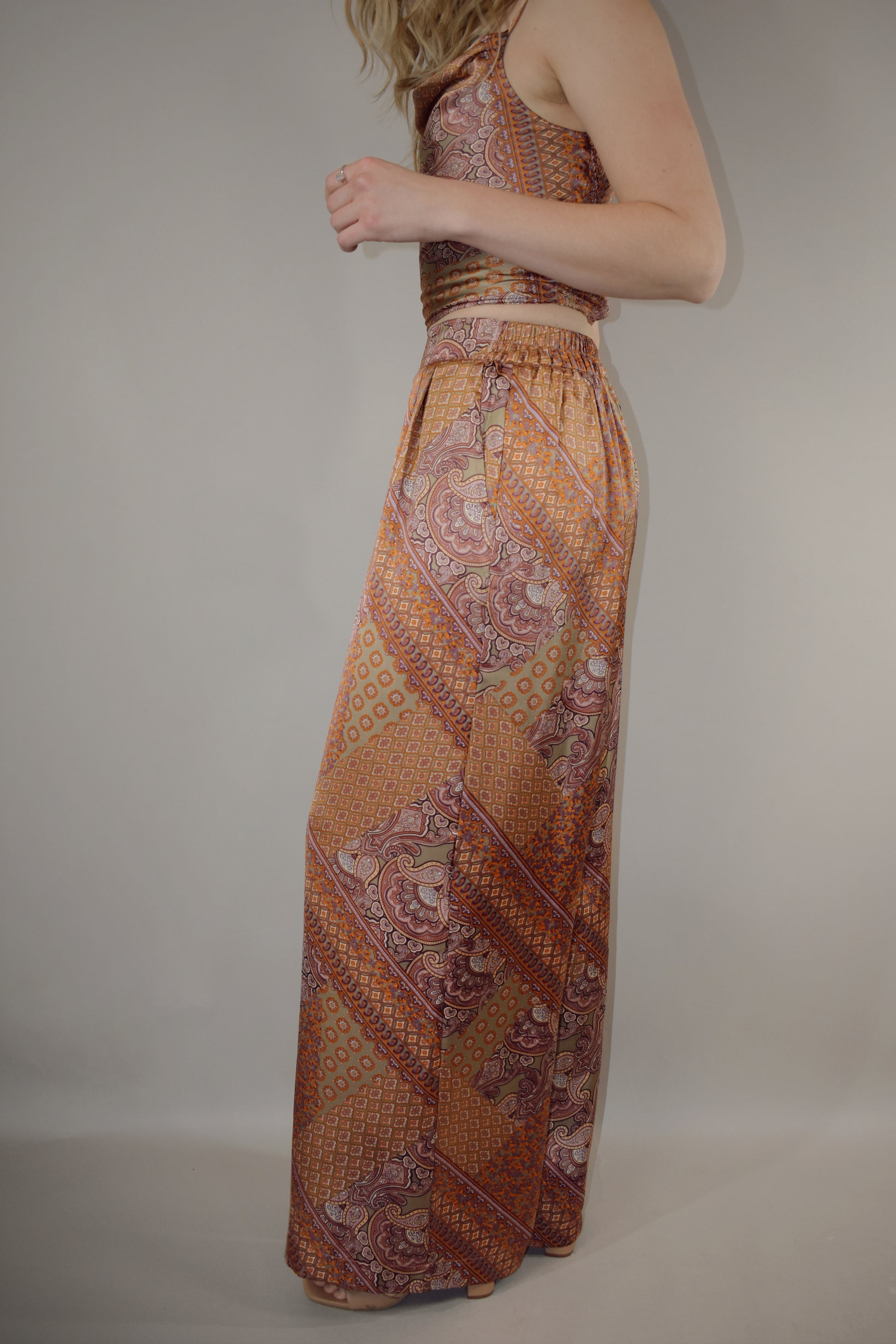 paisley printed satin high waisted full length wide leg pants with fitted band at waist and elastic stretch on back of band has pockets and pleats on front