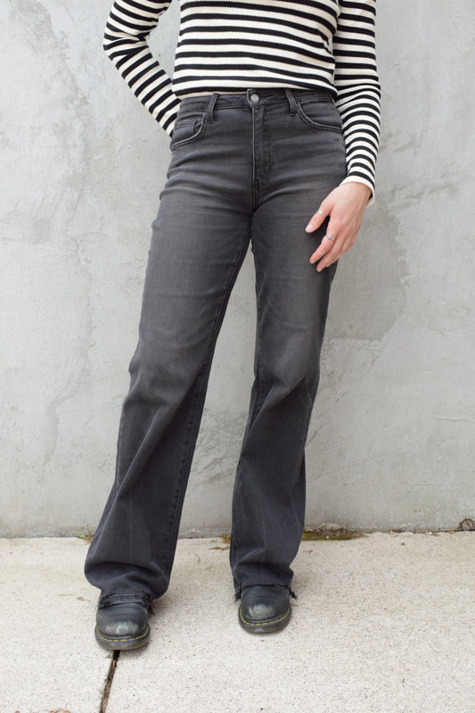 high rise washed black wide leg flare jeans full length stretch denim distressed hem but no holes zip and button enclosure has beltloops has front and back pockets 