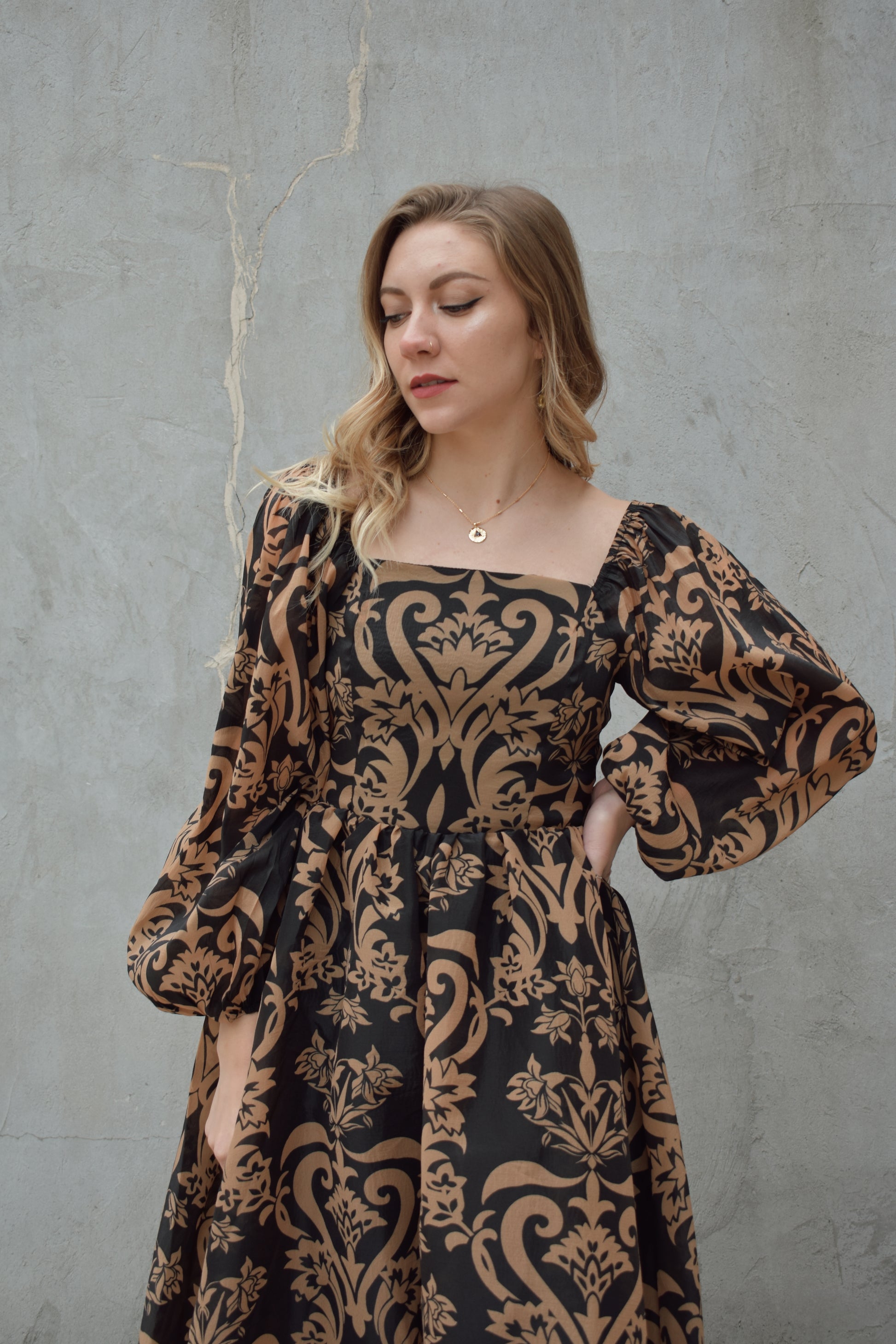 black and dark taupe dark bohemian print midi dress with square neckline front and back, balloon sleeves, flowy skirt, and zip back enclosure