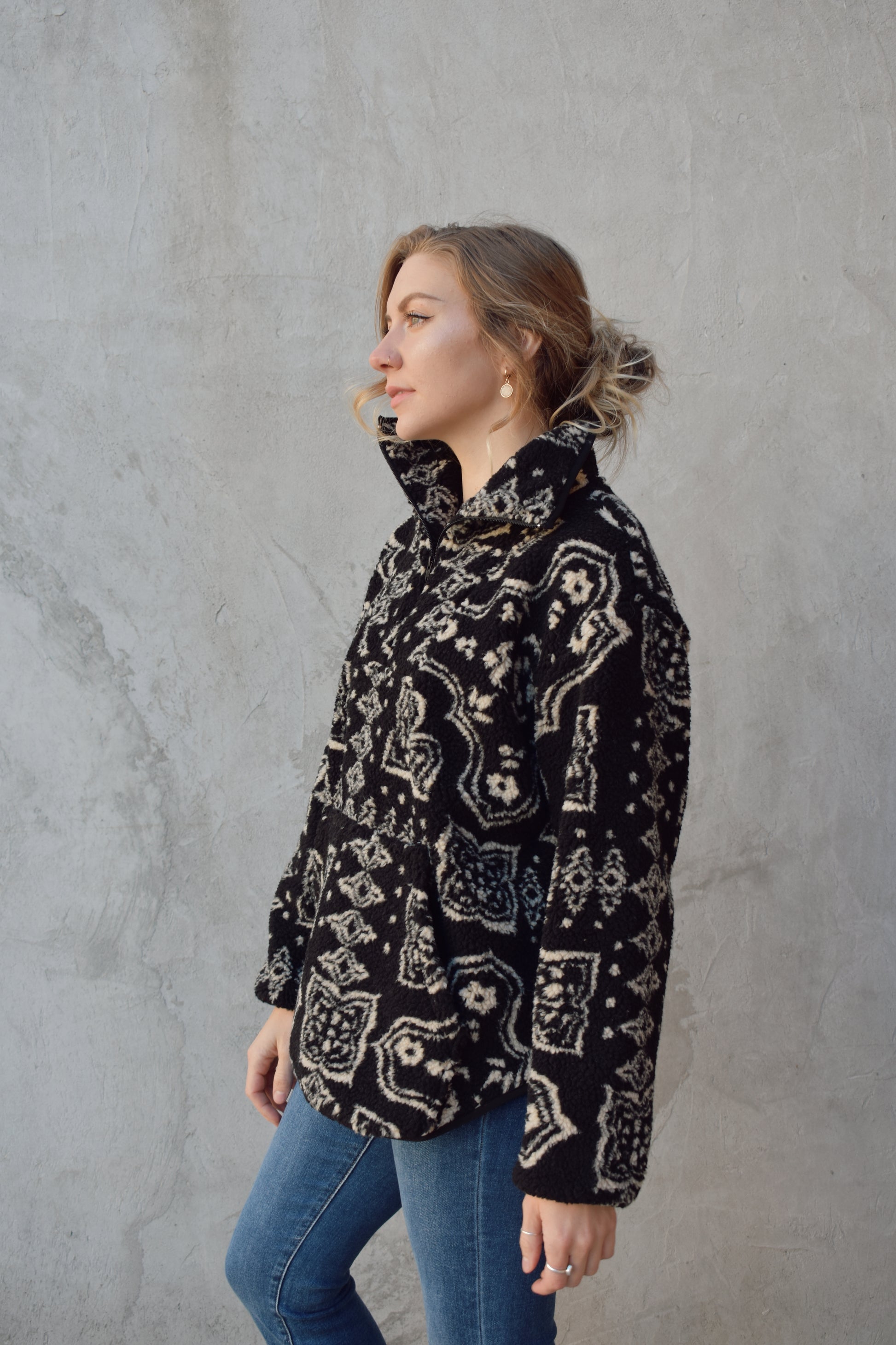 full length sherpa pullover with hoddie pocket, quarter zip with collar, black background with cream paisley pattern