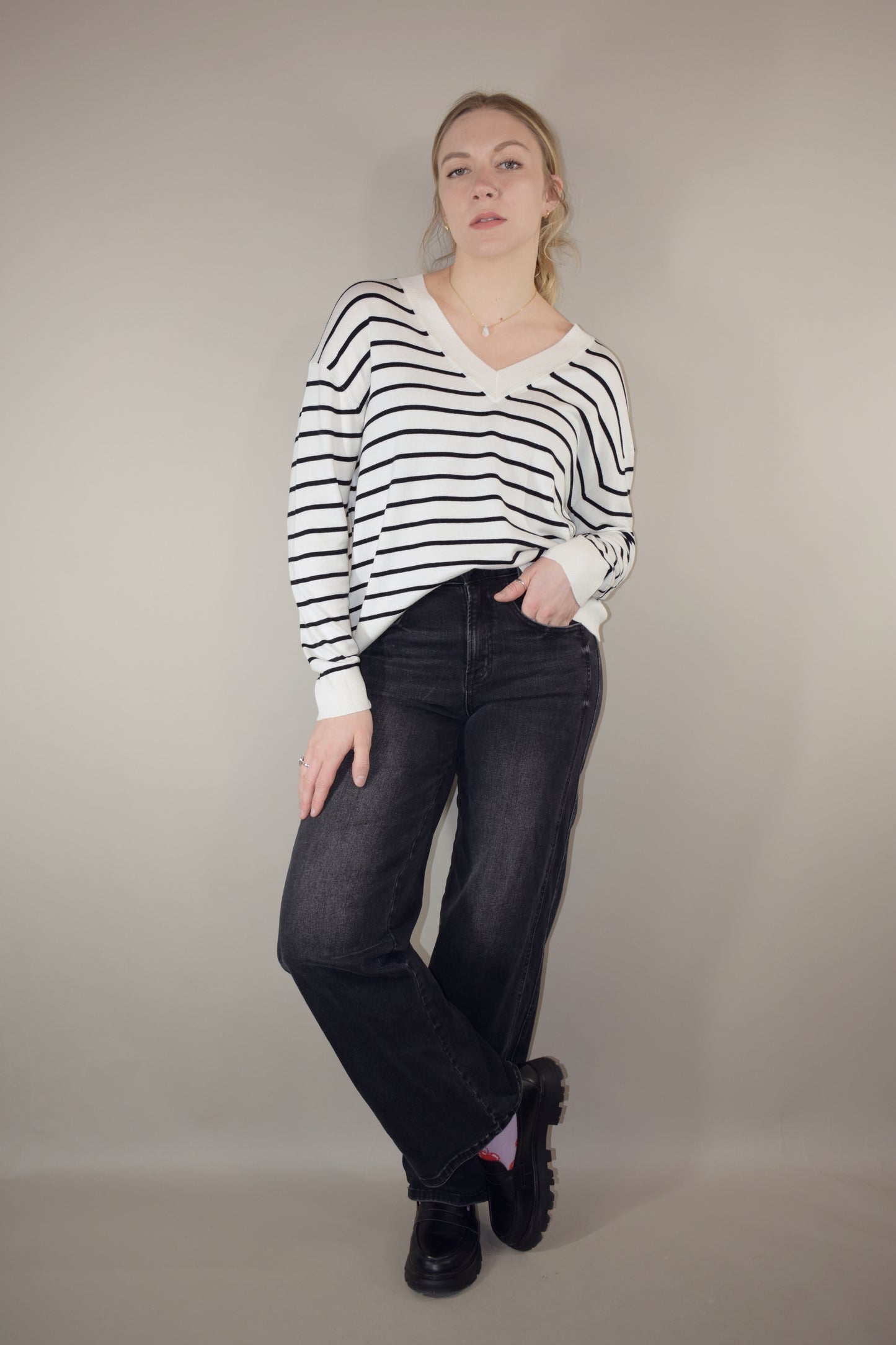 long sleeve full length v neck light weight sweater with horizontal black stripes, solid white hem, loose fit, drop shoulders, super soft.