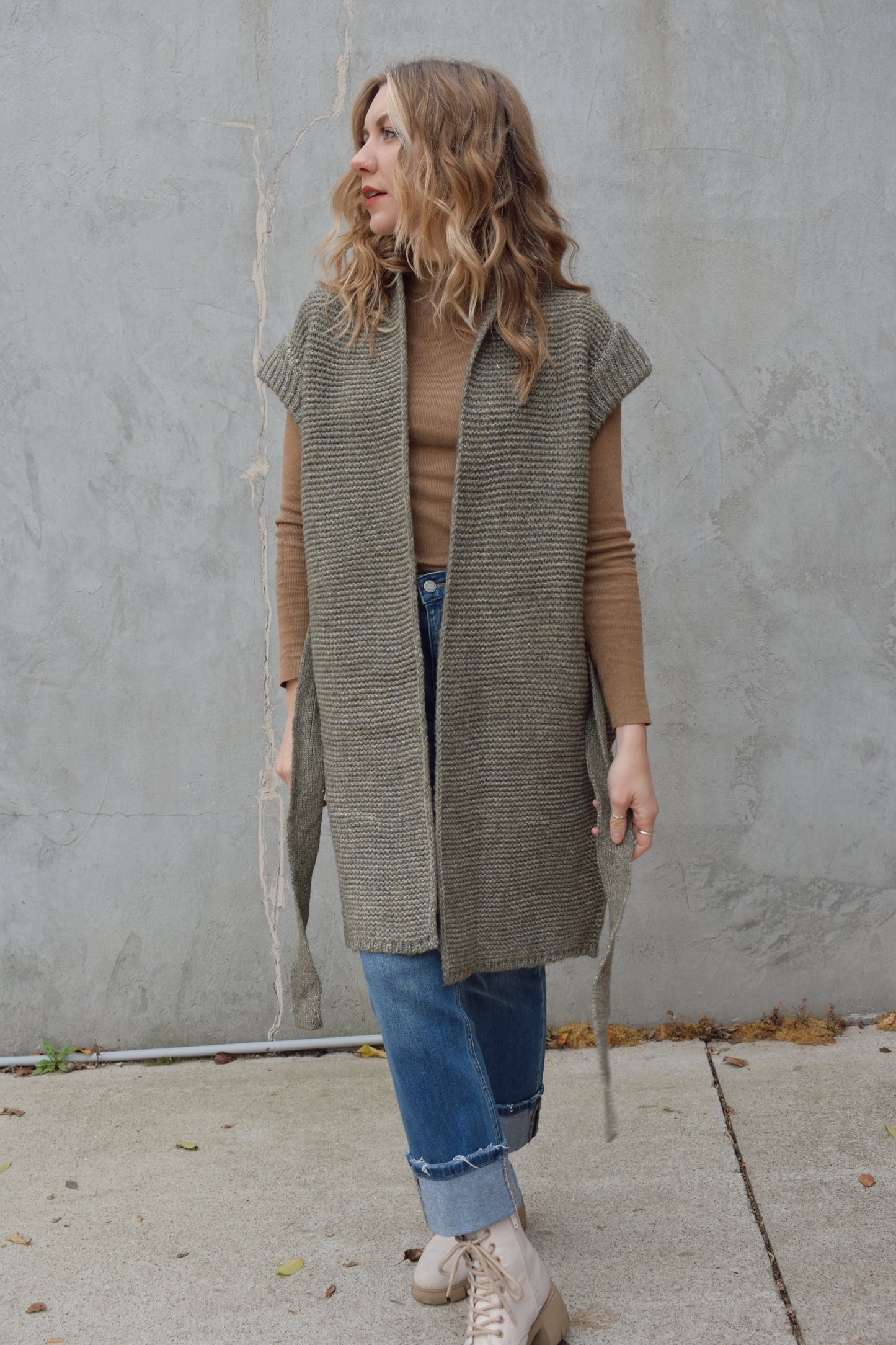 belted sleeveless cardigan vest with thick cap sleeve detail. woven olive green material. hits above the knee.