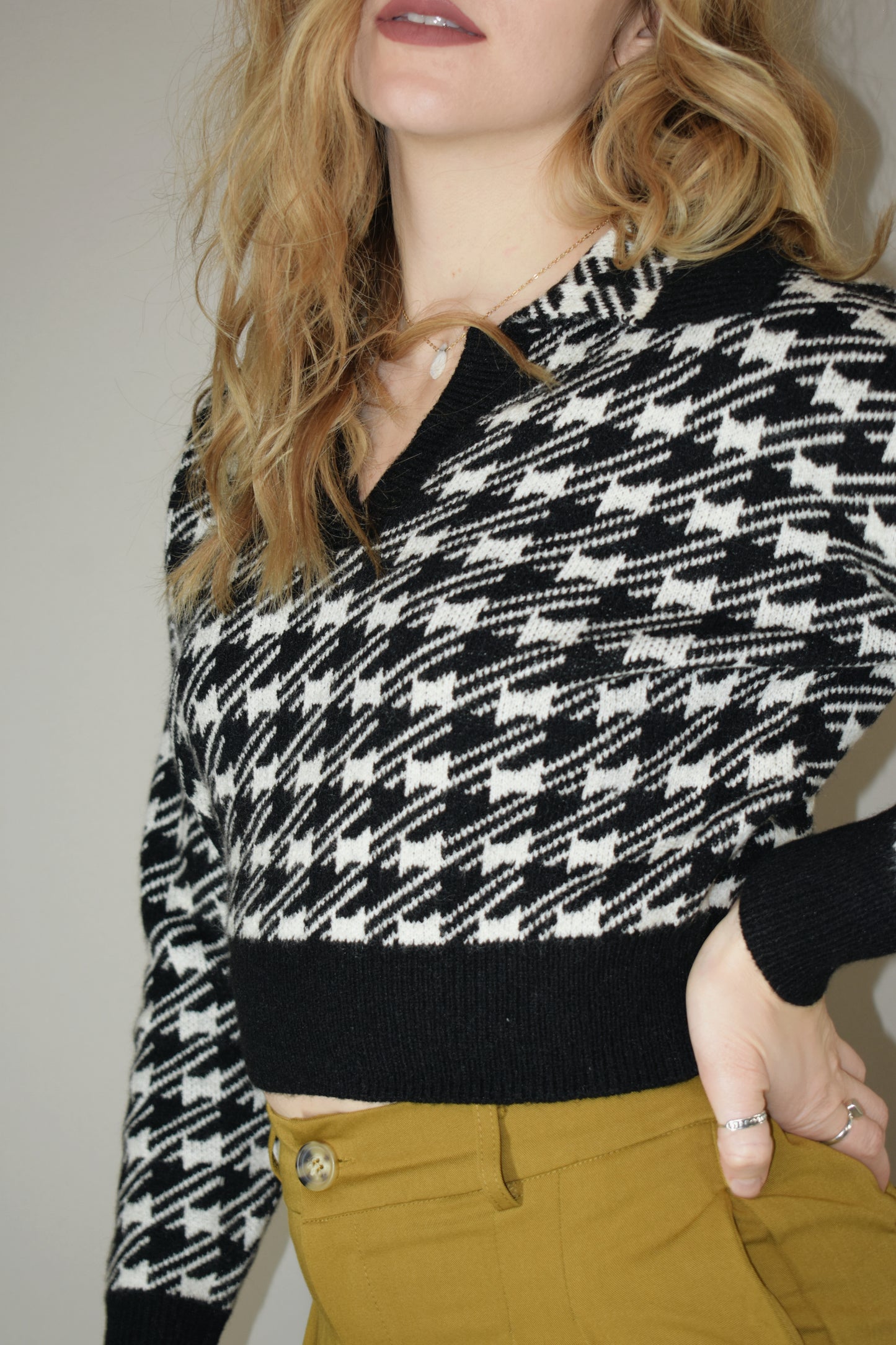 cropped collared houndstooth sweater with v neck and solid black outline on hem cuffs and neckline