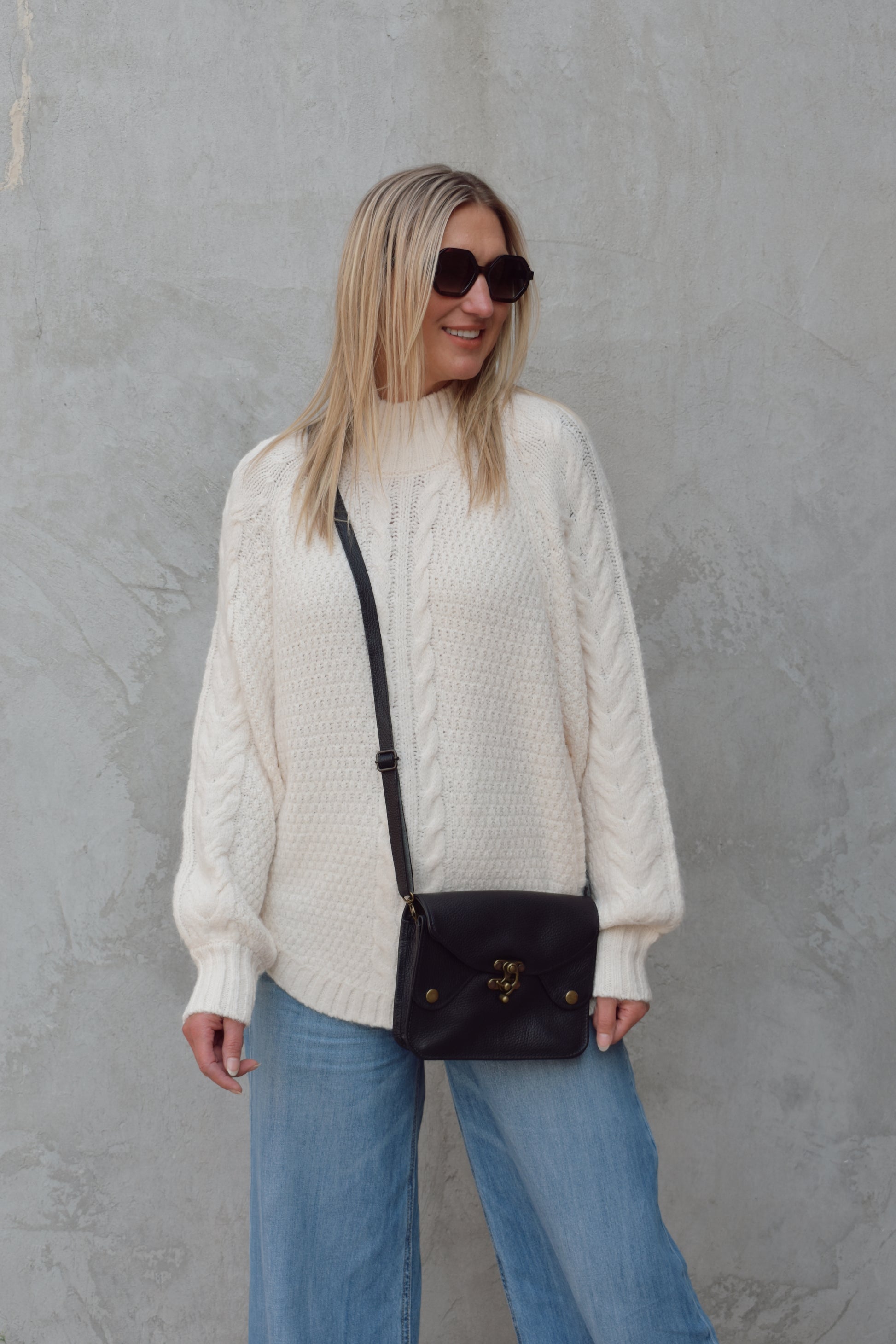 mock neck full length sweater with ribbed detailing around trim and chunky cable knit down the front and down the sleeves. rounded hem, slouchy sleeves.