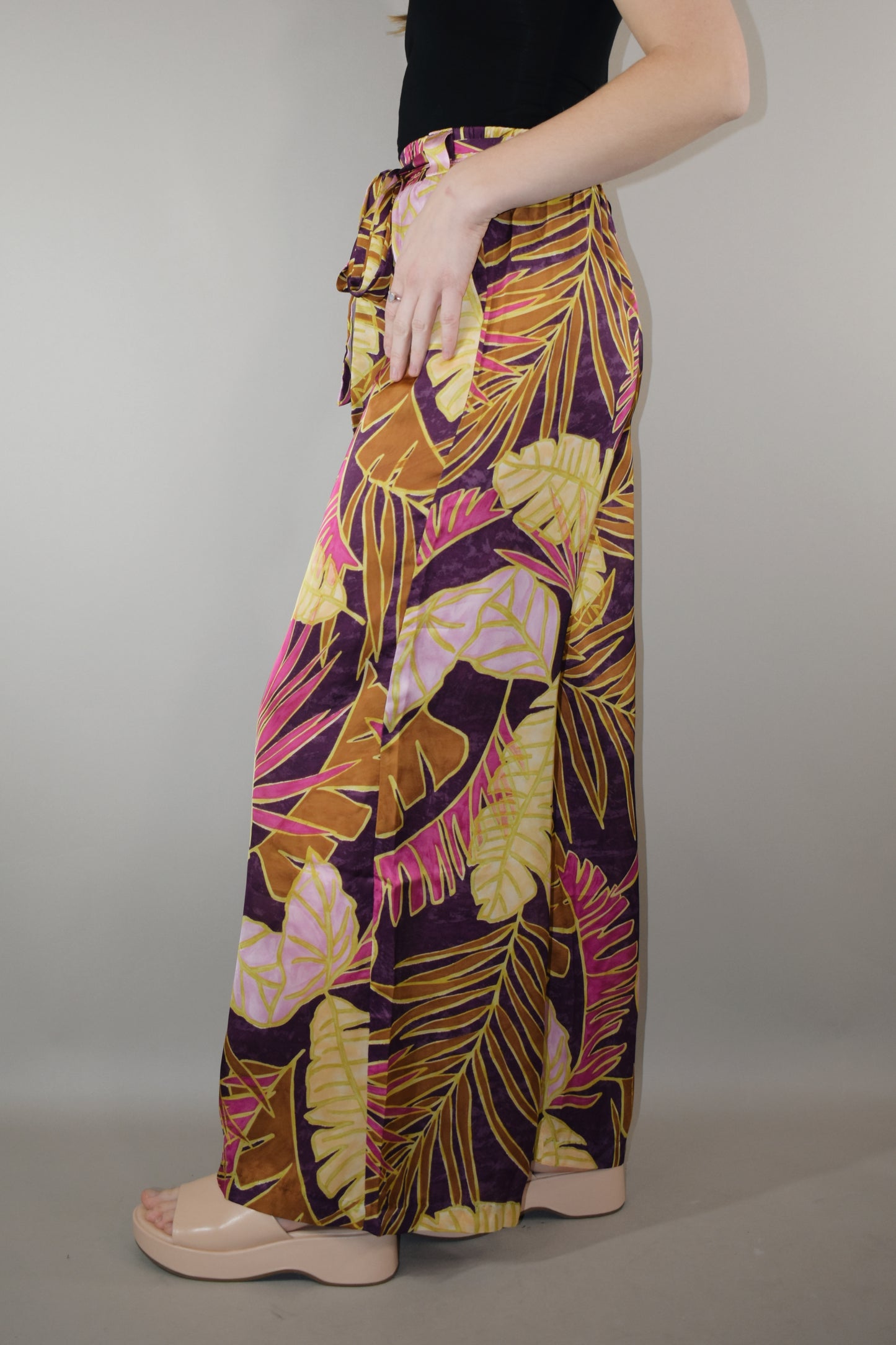 satin wide leg pants high waisted full length with elastic on back of waistband satin sash waist tie has beltloops and pockets tropical print with magenta cream and blush tones