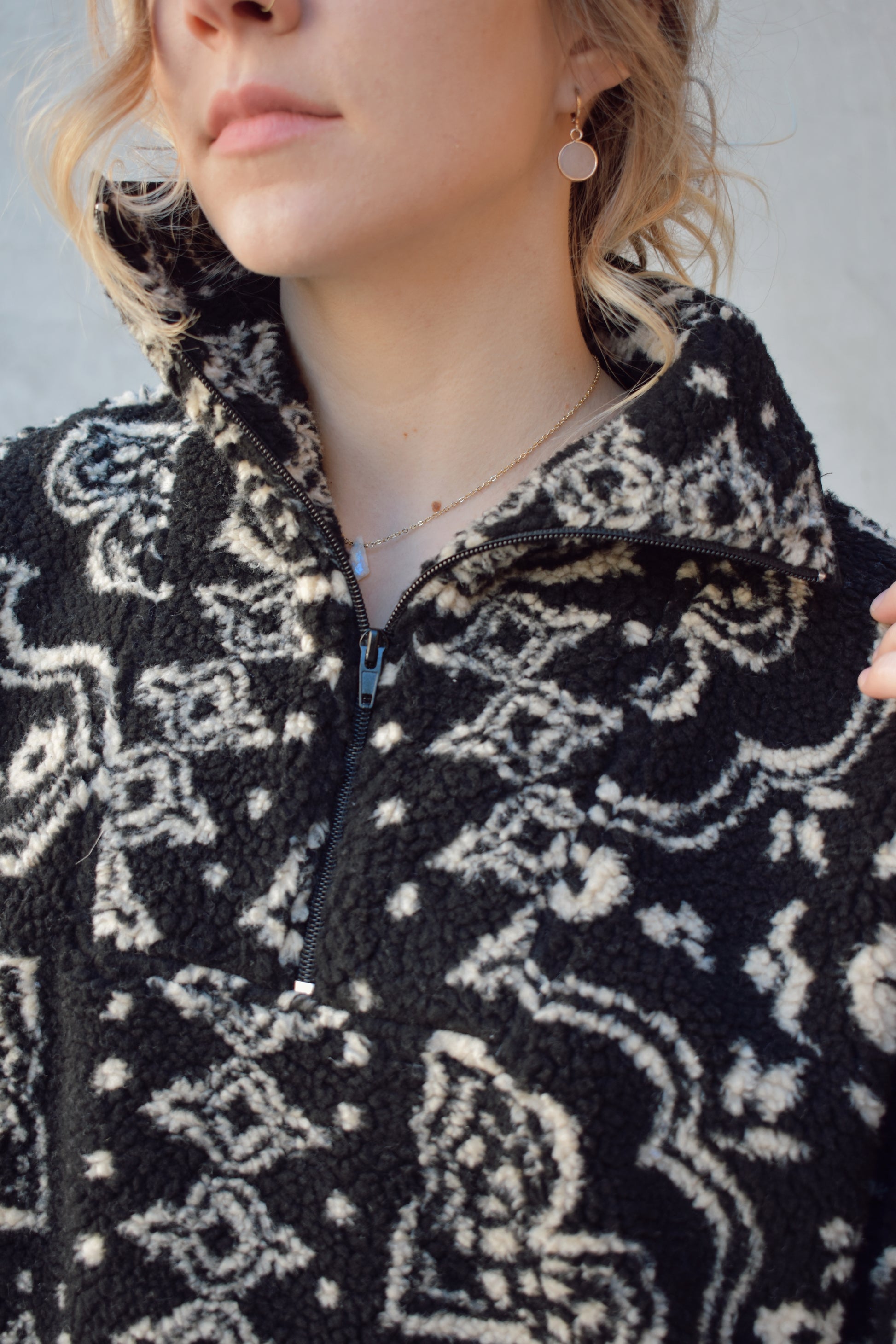 full length sherpa pullover with hoddie pocket, quarter zip with collar, black background with cream paisley pattern