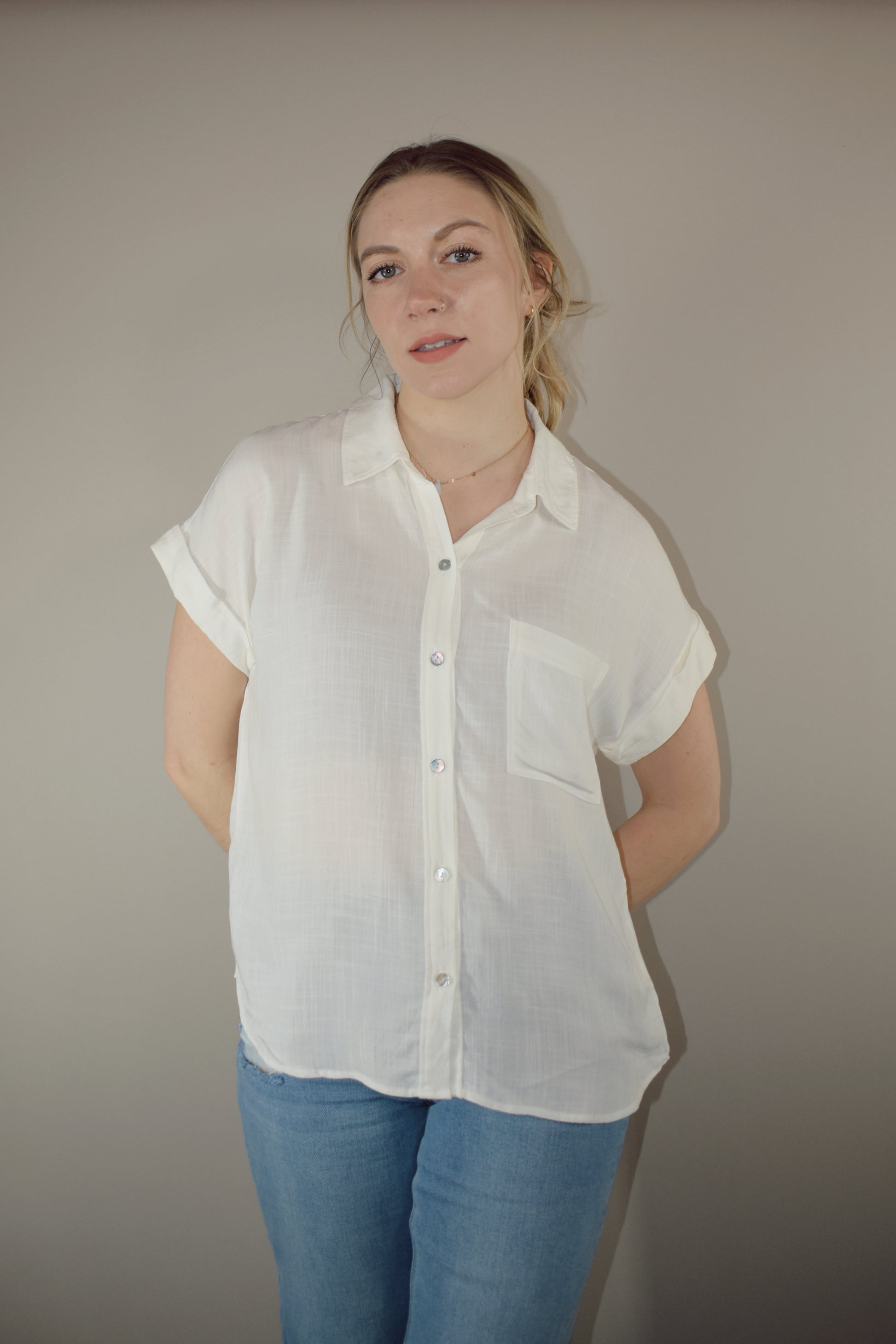 rayon white short sleeve collared button down with cuffed sleeves, one breast patch pocket, loose fit, full length, lightweight.