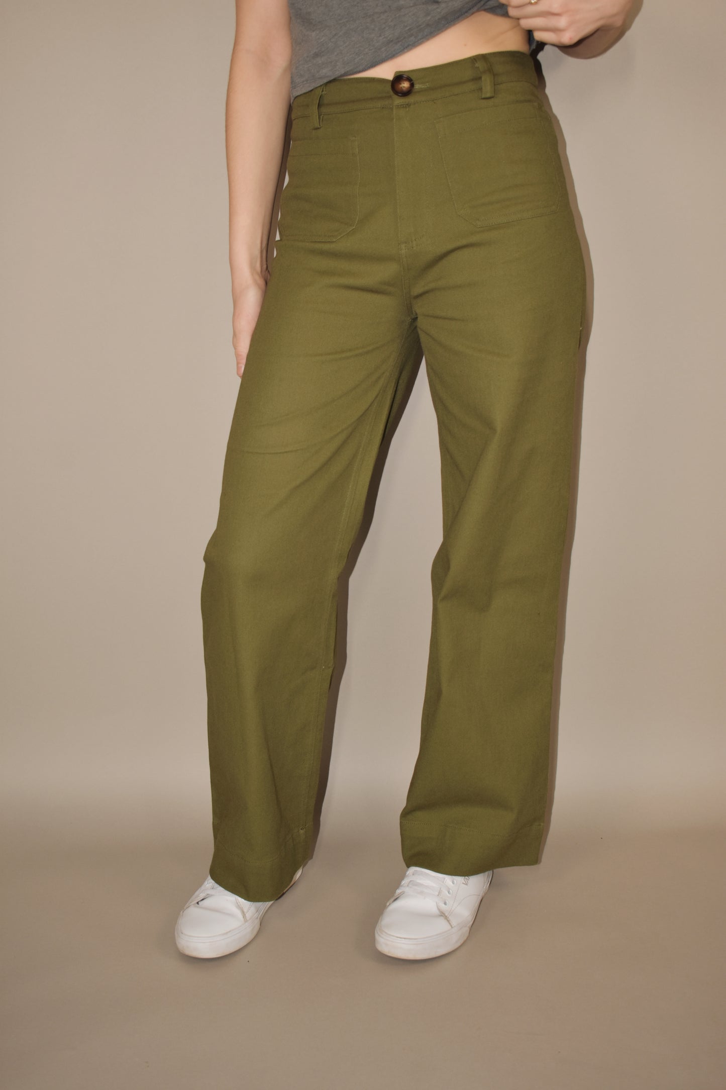 wide leg full length stretchy olive denim pants with brown front button. retro patch pockets on front and has back pockets too. no holes. high waisted.