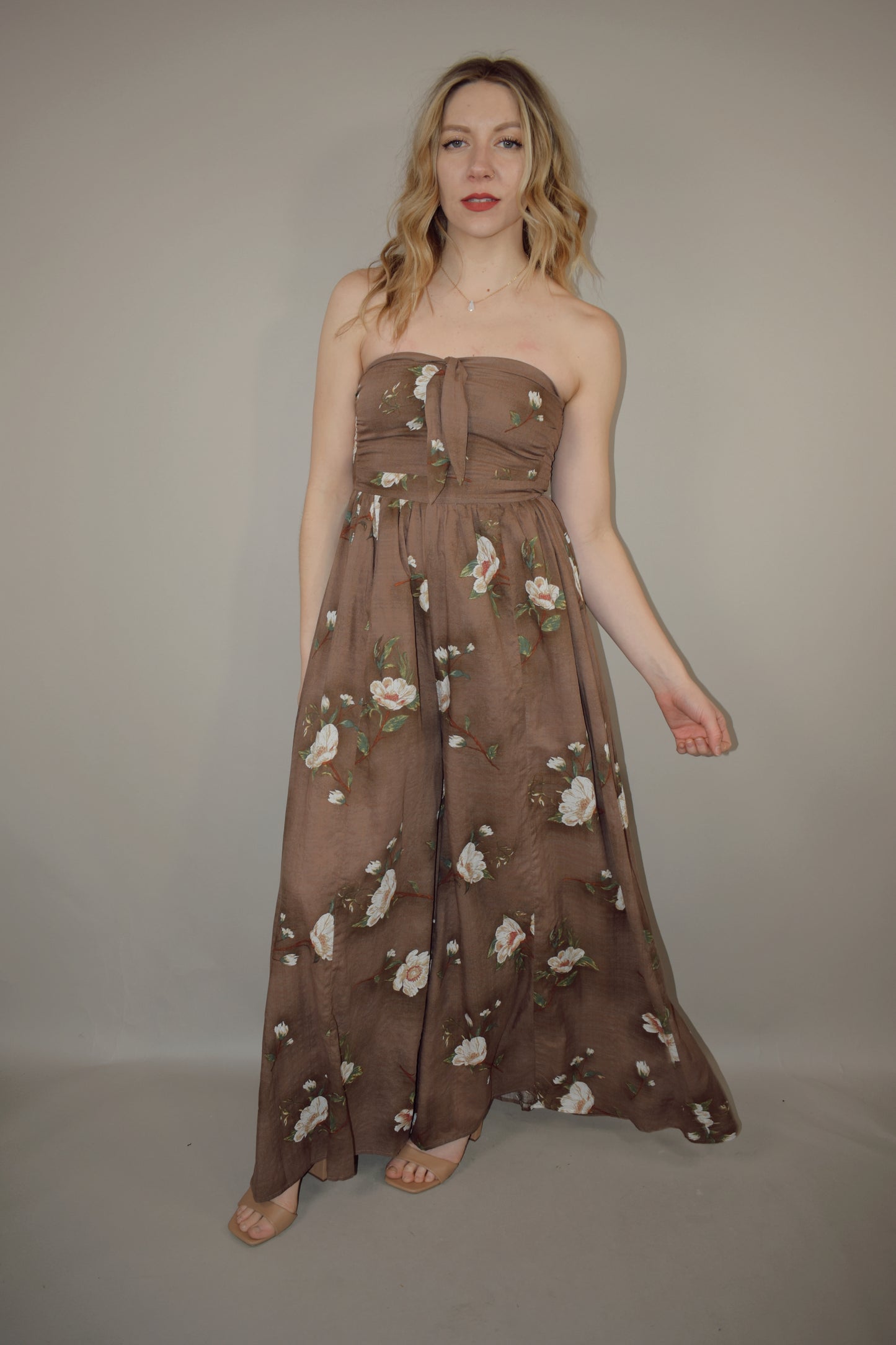 strapless wide leg flowy floral jumpsuit with tie and eyelet hole on front of bodice, has a elastic back panel on bodice full length, no pockets, is lined