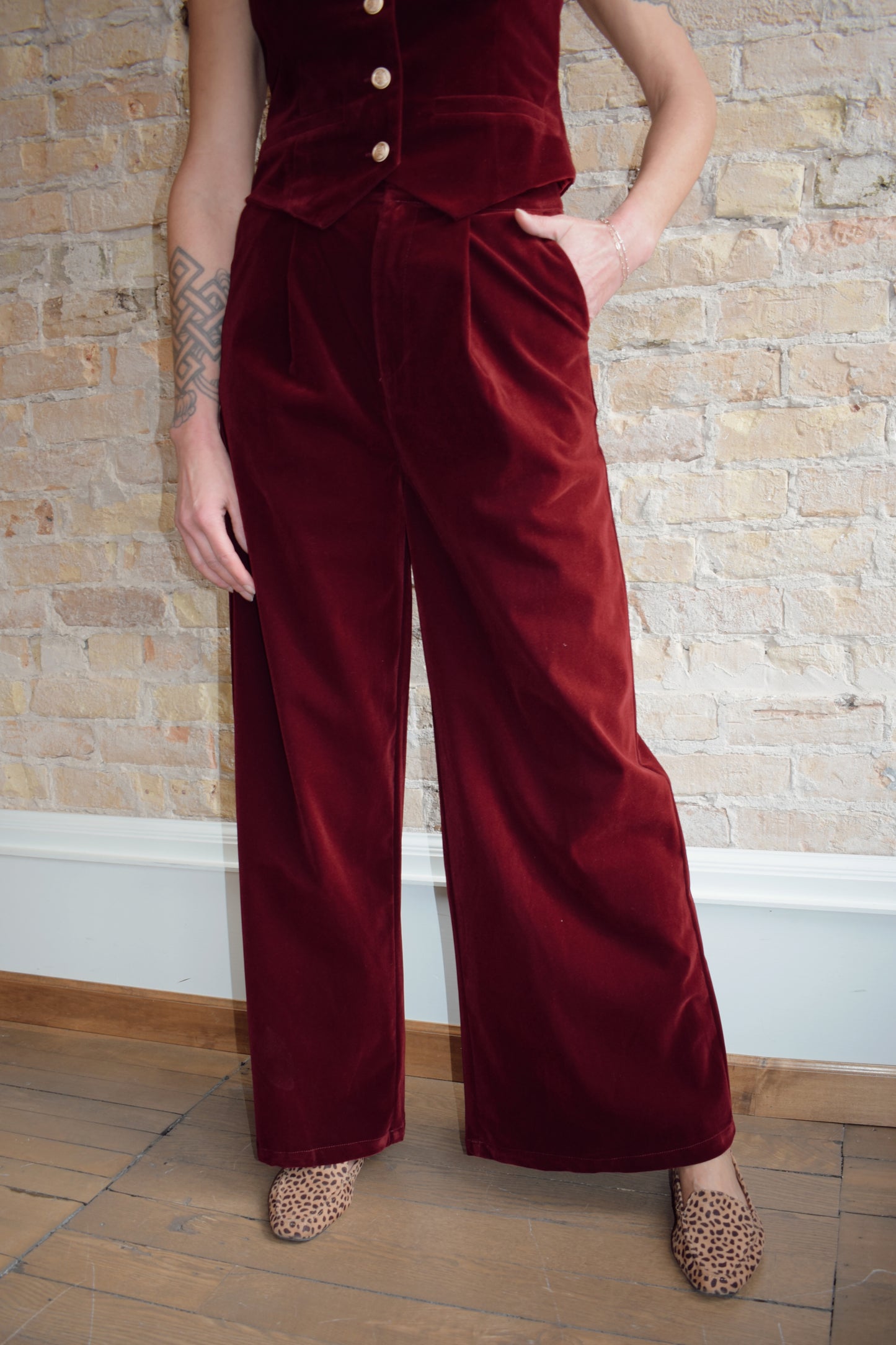 burgundy velvet trousers with zip and clasp enclosure has pockets and pleats