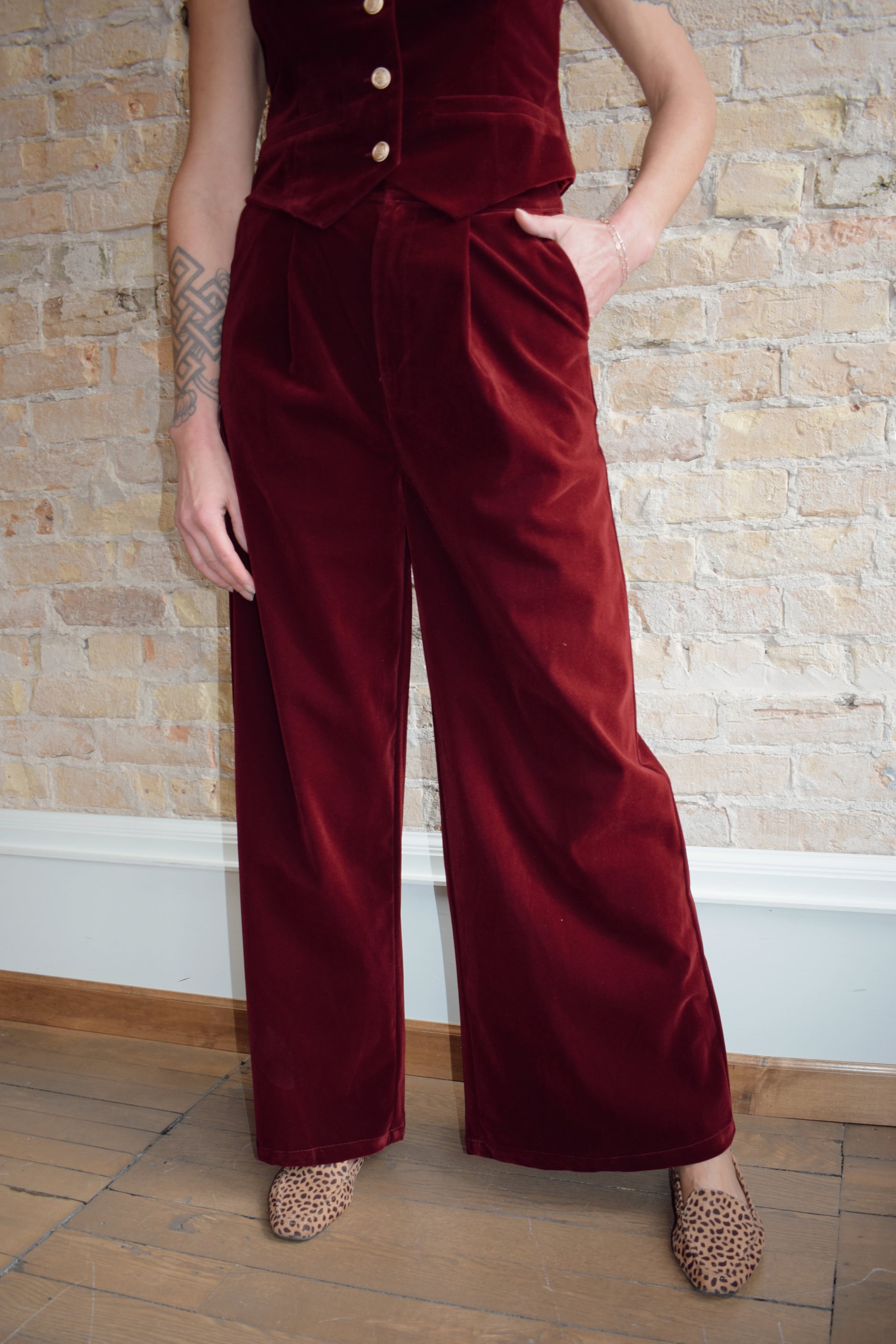 burgundy velvet trousers with zip and clasp enclosure has pockets and pleats