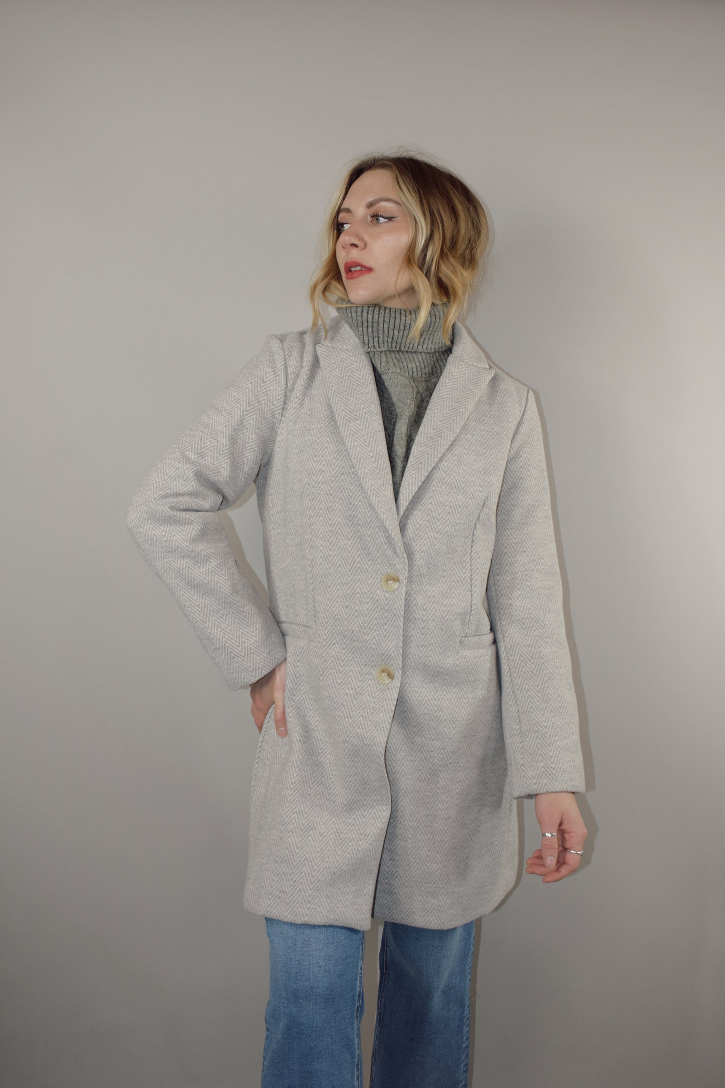 chevron longline blazer hits mid thigh with button detail along cuffs and two button enclosure on front, has pockets