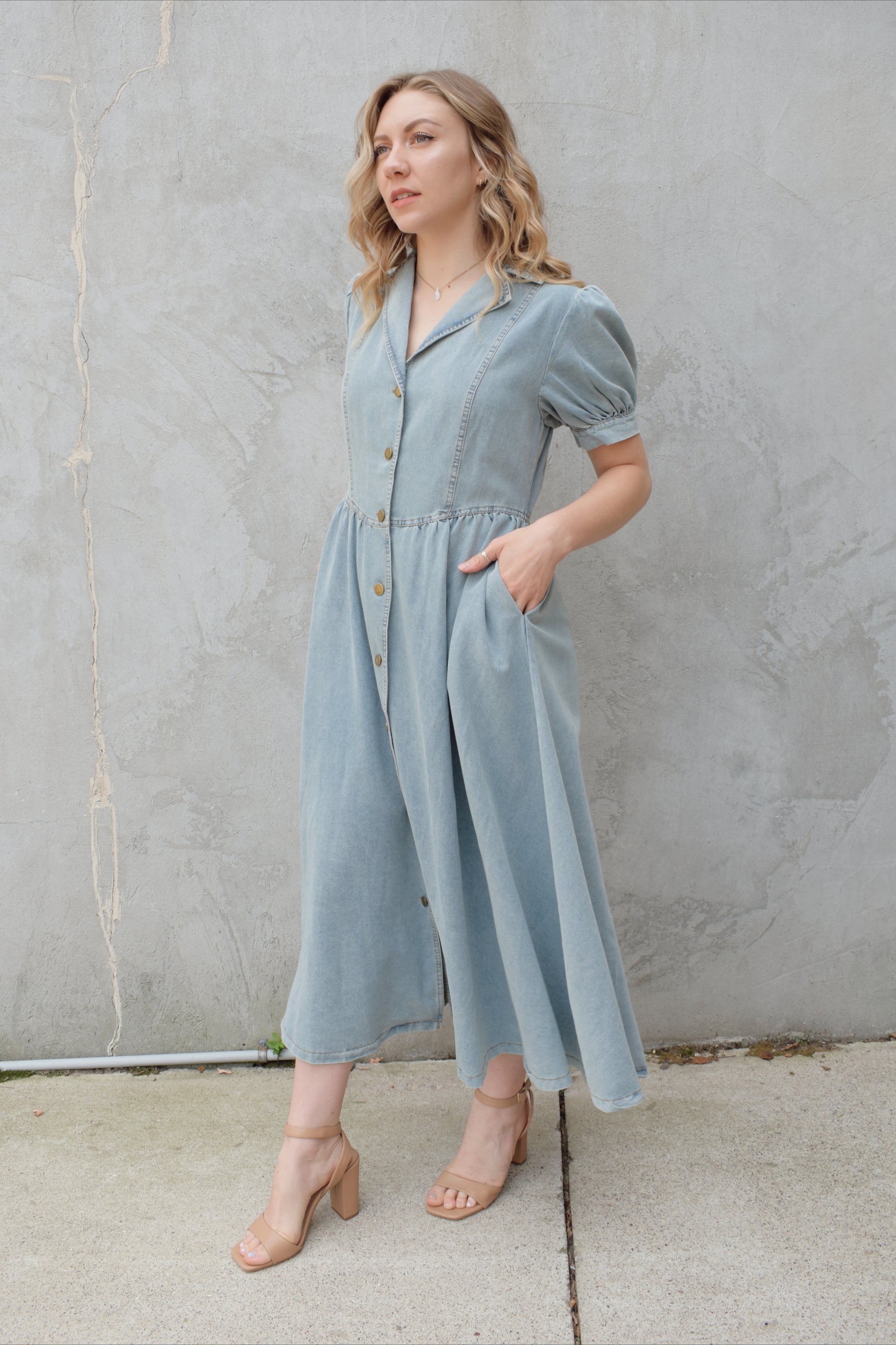 denim midi dress light wash with puff short sleeves with button cuffs button down front, v neck and collar, gathered at waist with a line skirt, has pockets