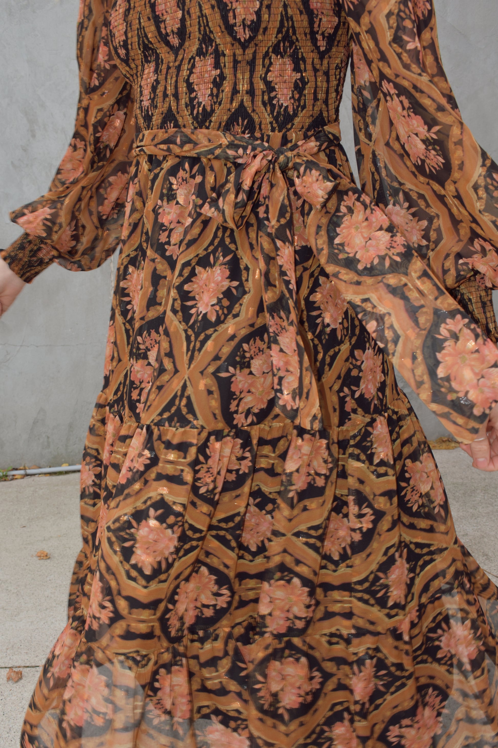 long sleeve high/mock neck midi dress with smocked bodice and cuffs, sheer sleeves, flowy skirt, fabric tie at waist, floral boho tapestry pattern. double button at back of neck