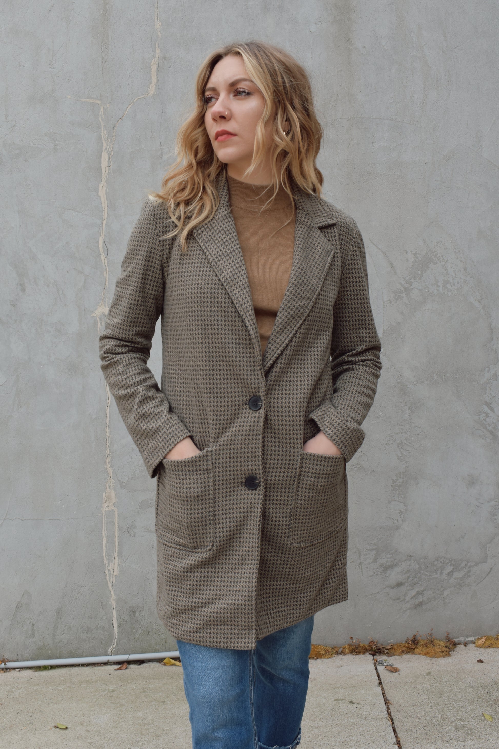 Houndstooth longline blazer, structured and fitted,  long sleeves, a notched collar, double button closure. patch pockets on front. hits above the knee.