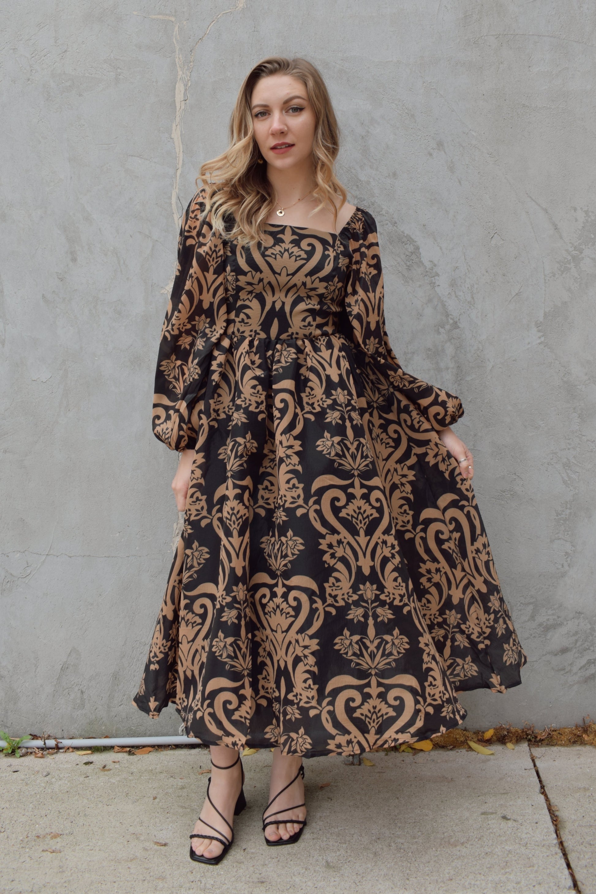 black and dark taupe dark bohemian print midi dress with square neckline front and back, balloon sleeves, flowy skirt, and zip back enclosure